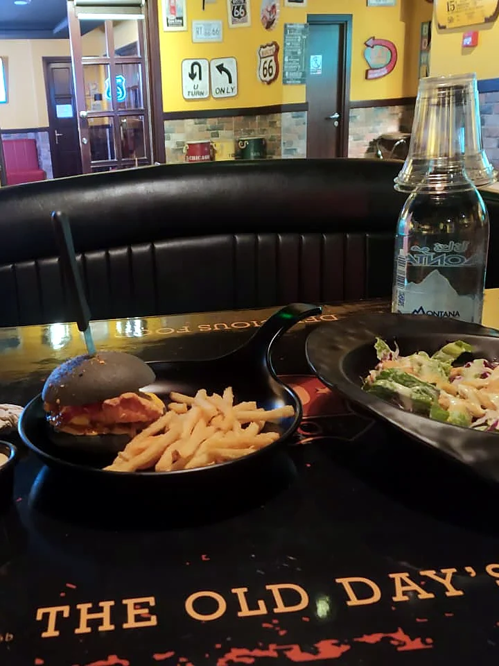 A burger, fries and a salad on a restaurant table.
